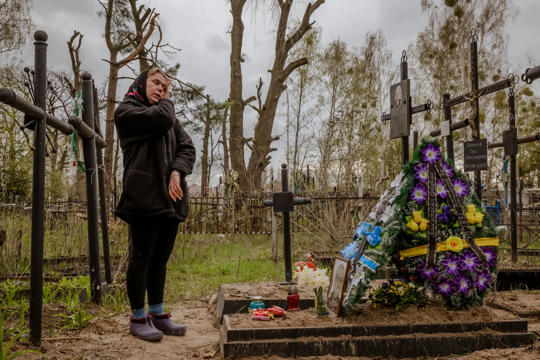 Ірина Абрамова відвідує могилу свого чоловіка Олега Абрамова у квітні 2022 року. Його вбили російські війська біля їхнього будинку в Бучі.